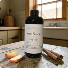 Load image into Gallery viewer, Bottle of 'Apple Harvest' mop soap on a wooden surface with apples and cinnamon sticks.