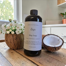 Load image into Gallery viewer, Bottle of Baja Mop Soap on a wooden surface with a coconut and flowers in the background