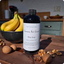 Load image into Gallery viewer, Mop soap bottle with banana nut bread scent on a wooden surface with bananas and nuts.