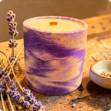 Load image into Gallery viewer, Candle with purple and white marbled design on a wooden surface with lavender and chamomile.