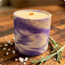 Load image into Gallery viewer, Candle with purple and white marbled design on a wooden surface with rosemary and sea salt.