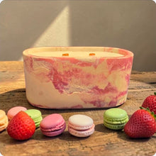 Load image into Gallery viewer, Marbled candle on a wooden surface with colorful macarons and strawberries.