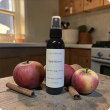 Load image into Gallery viewer, Bottle of 'Apple Harvest' spray on a kitchen counter with apples and cinnamon sticks.

