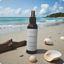 Load image into Gallery viewer, Spray bottle labeled 'Beach Bum Bum' on a sandy beach with shells and driftwood.
