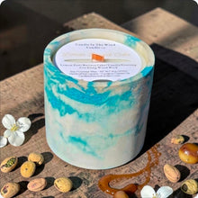 Load image into Gallery viewer, Candle with a marbled design on a stone surface with pistachio nuts, caramel and jasmine flowers
