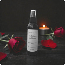 Load image into Gallery viewer, Bottle of 'Dark Rose &amp; Labdanum' product with red roses and a candle on a dark surface
