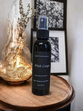 Load image into Gallery viewer, A black spray bottle labeled 'Fruit Loops' positioned on a wooden surface with a decorative object in the background.
