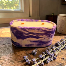 Load image into Gallery viewer, Marbled purple concrete candle on a wooden surface with lavender flowers
