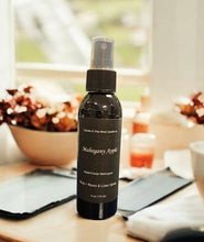 Load image into Gallery viewer, Black spray bottle labeled 'Mahogany Apple' on a blurred background
