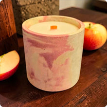 Load image into Gallery viewer, Candle in a decorative concrete container with apples on a wooden surface
