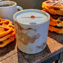 Load image into Gallery viewer, Candle in a decorative concrete container with waffles and coffee on a wooden surface
