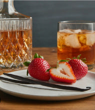 Load image into Gallery viewer, Glass of Bourbon with strawberries and vanilla beans on a plate
