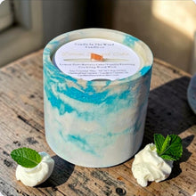 Load image into Gallery viewer, Marbled candle on a wooden surface with whipped cream and mint leaves.
